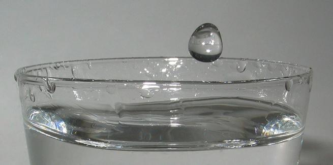Uma gota d'água caindo na água em um copo